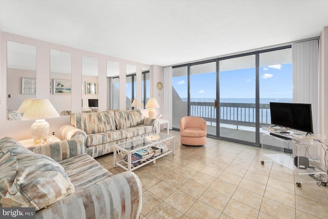 tiled living room featuring floor to ceiling windows, a water view, and a healthy amount of sunlight