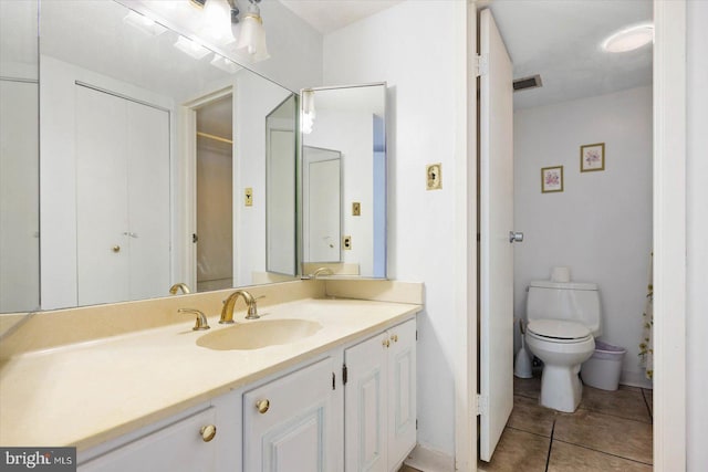 bathroom with tile floors, toilet, and vanity