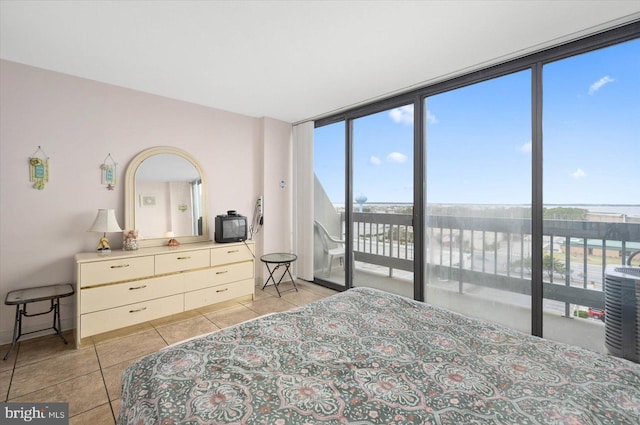 tiled bedroom with floor to ceiling windows, multiple windows, and access to outside