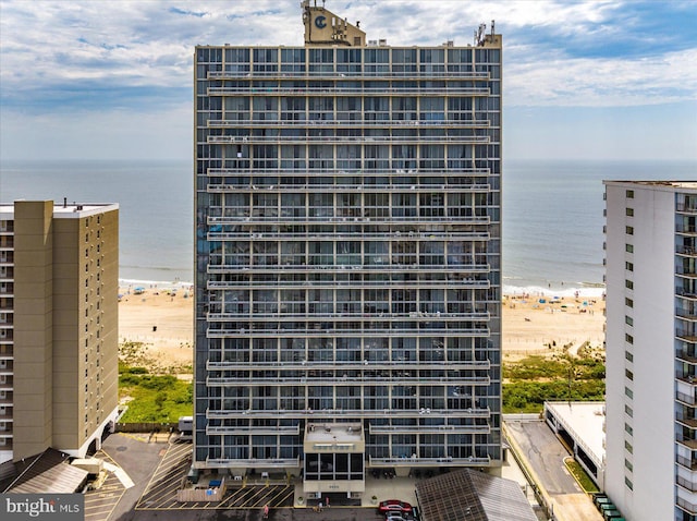 view of building exterior with a beach view and a water view