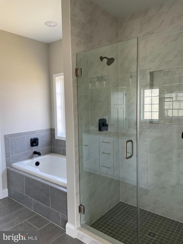 bathroom featuring plus walk in shower and tile floors