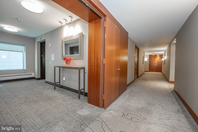 corridor with light carpet and a baseboard radiator