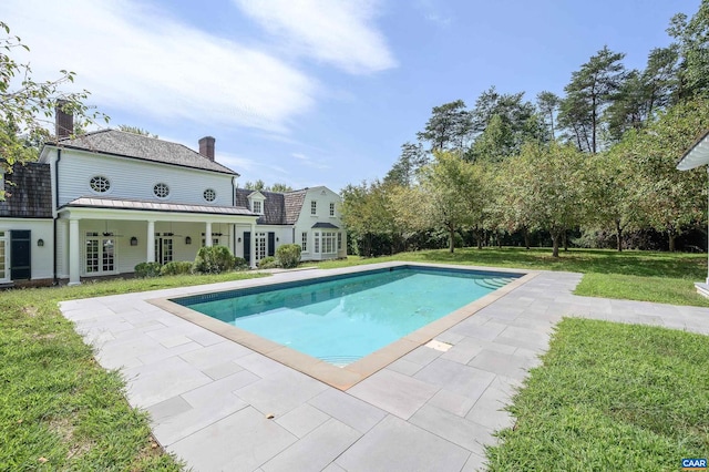 view of swimming pool with a lawn, ceiling fan, and a patio area