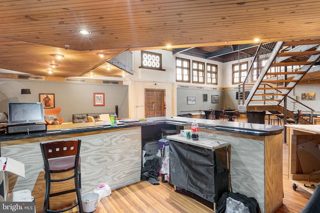 kitchen with wooden ceiling, a towering ceiling, light wood-type flooring, and kitchen peninsula