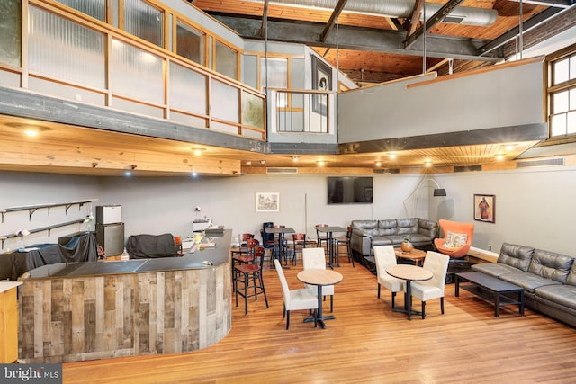 living room featuring a towering ceiling and light hardwood / wood-style flooring