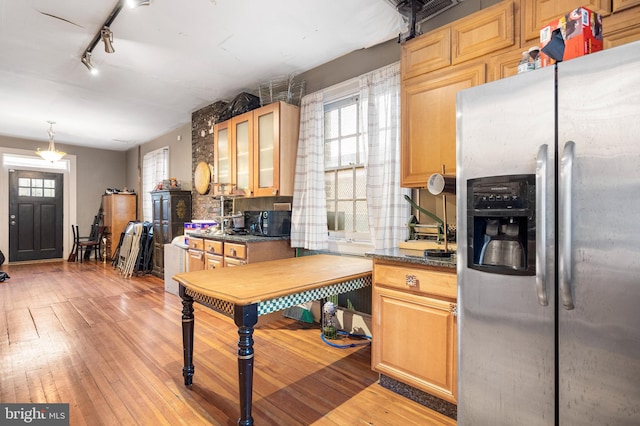 kitchen with decorative light fixtures, rail lighting, backsplash, light wood-type flooring, and stainless steel refrigerator with ice dispenser