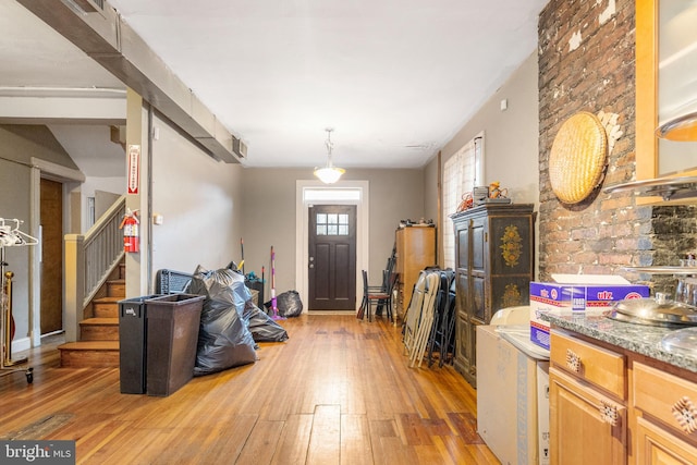 interior space with light hardwood / wood-style flooring, hanging light fixtures, light brown cabinetry, and light stone counters