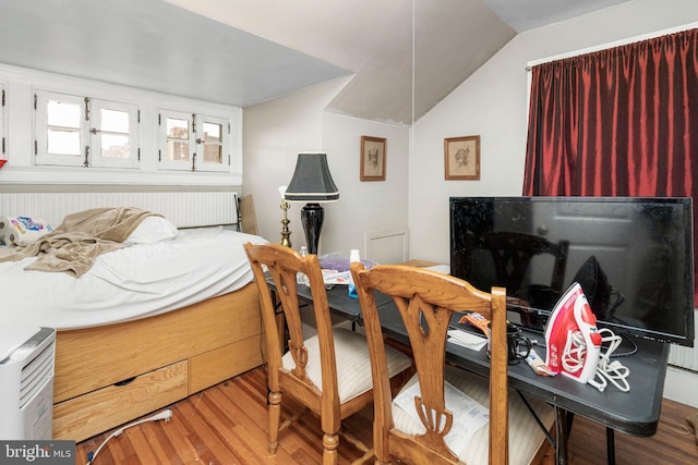 bedroom featuring lofted ceiling and light hardwood / wood-style flooring