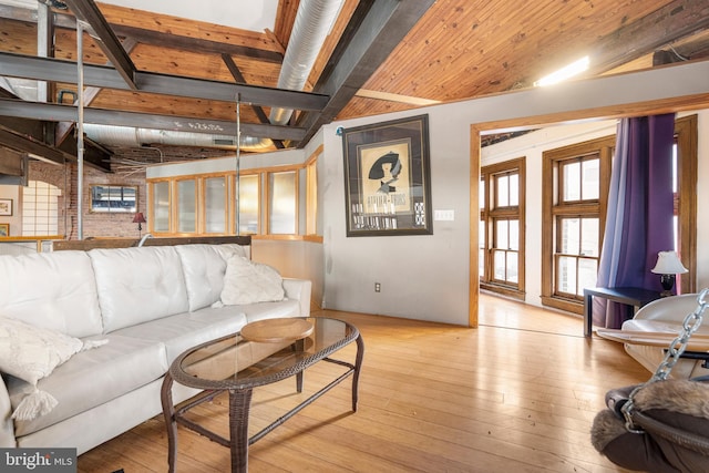 living room with lofted ceiling with beams and light hardwood / wood-style flooring