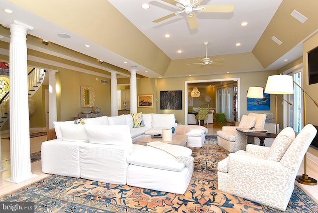 living room featuring a tray ceiling, light hardwood / wood-style flooring, ceiling fan, decorative columns, and vaulted ceiling