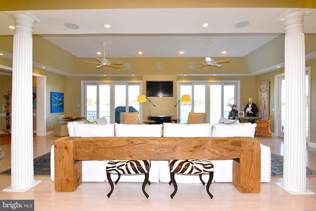 kitchen with ceiling fan, french doors, a breakfast bar, light wood-type flooring, and ornate columns