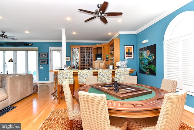 dining room with ornamental molding, light hardwood / wood-style floors, ceiling fan, and ornate columns