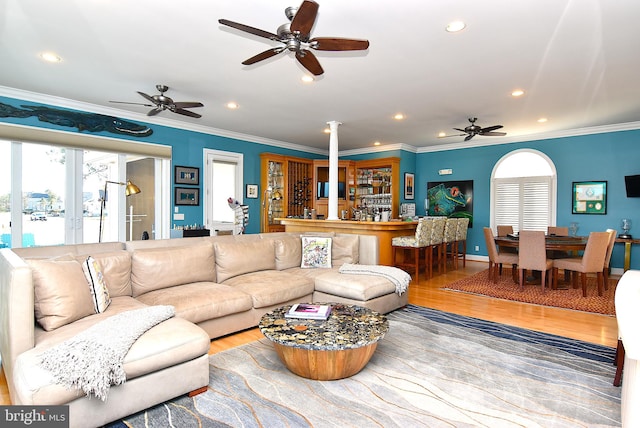 living room featuring ceiling fan, light wood-type flooring, ornamental molding, and french doors