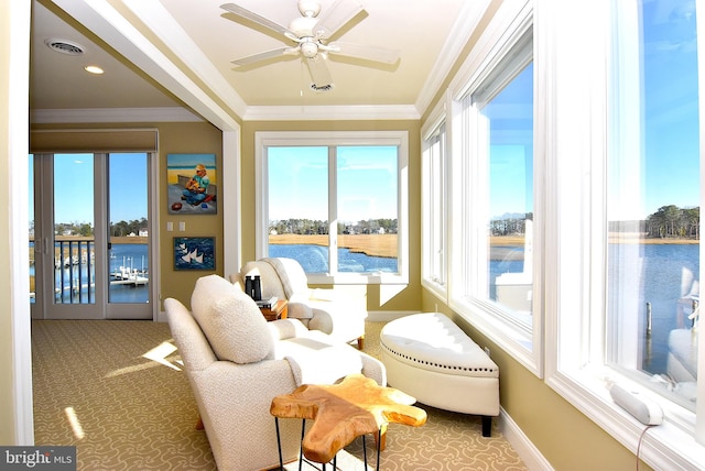 sunroom featuring ceiling fan, a water view, and a wealth of natural light