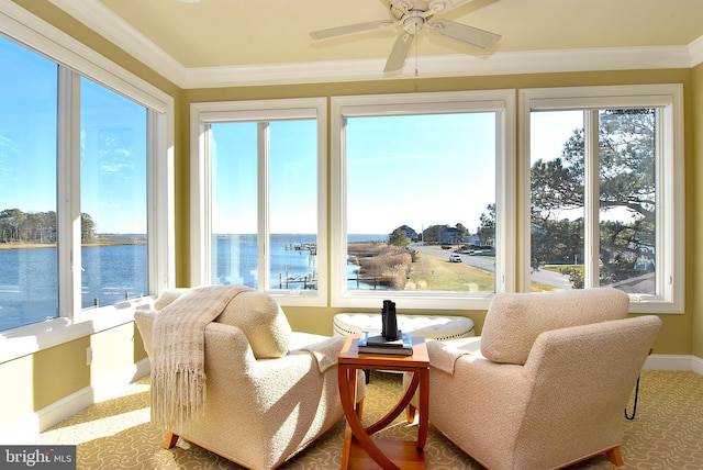 sunroom / solarium featuring a water view and ceiling fan