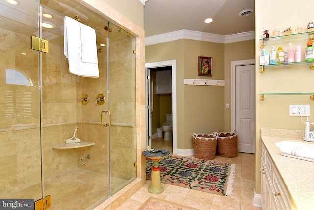 bathroom featuring tile flooring, a shower with shower door, toilet, vanity, and ornamental molding