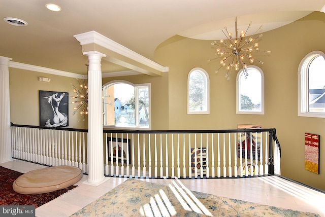 interior space with light hardwood / wood-style flooring, decorative columns, ornamental molding, and a chandelier