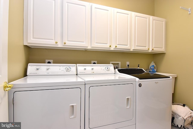 washroom featuring washer hookup, washing machine and clothes dryer, electric dryer hookup, and cabinets