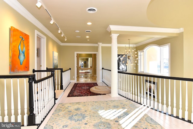 hall with a notable chandelier, ornamental molding, decorative columns, and rail lighting