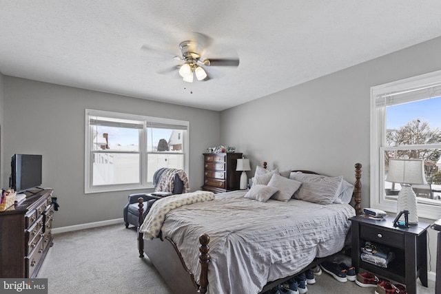 carpeted bedroom with ceiling fan and a textured ceiling