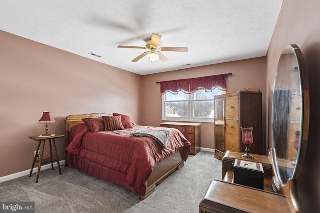 bedroom with ceiling fan, light colored carpet, and a textured ceiling