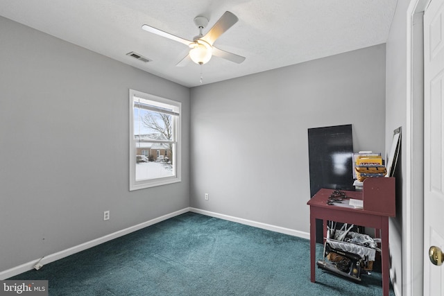 interior space featuring dark carpet and ceiling fan