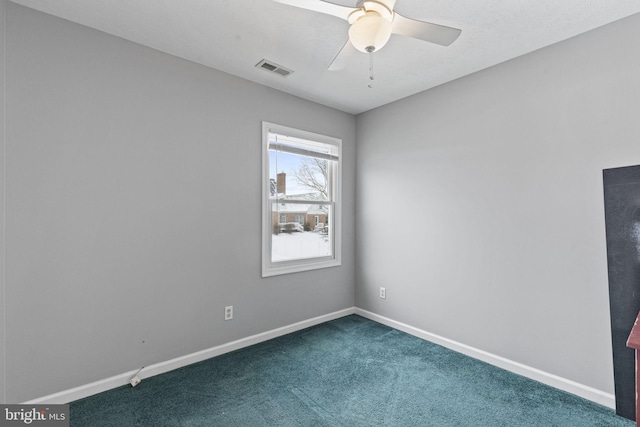 spare room with ceiling fan and dark colored carpet