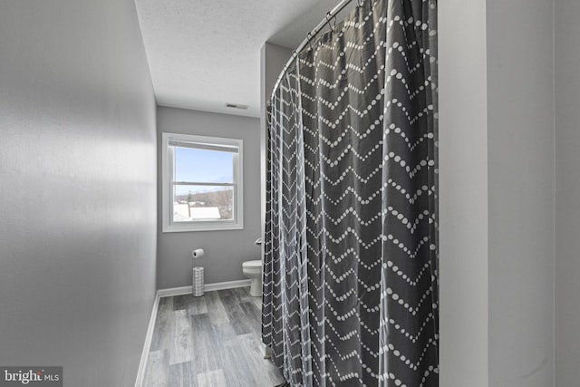 bathroom featuring hardwood / wood-style floors and toilet