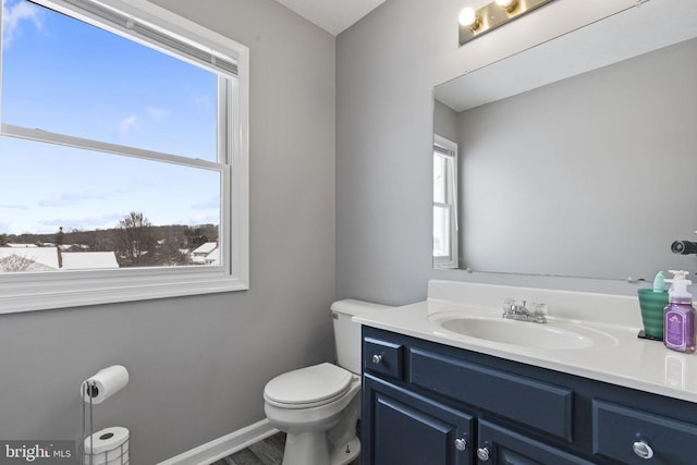 bathroom featuring hardwood / wood-style flooring, toilet, and vanity