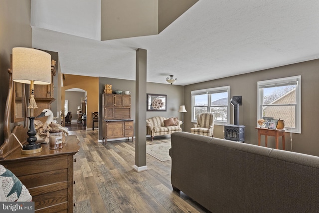 living room with dark hardwood / wood-style floors, a textured ceiling, and a wood stove