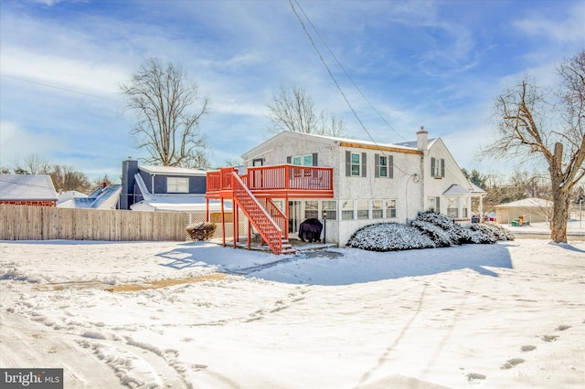 snow covered rear of property featuring a wooden deck