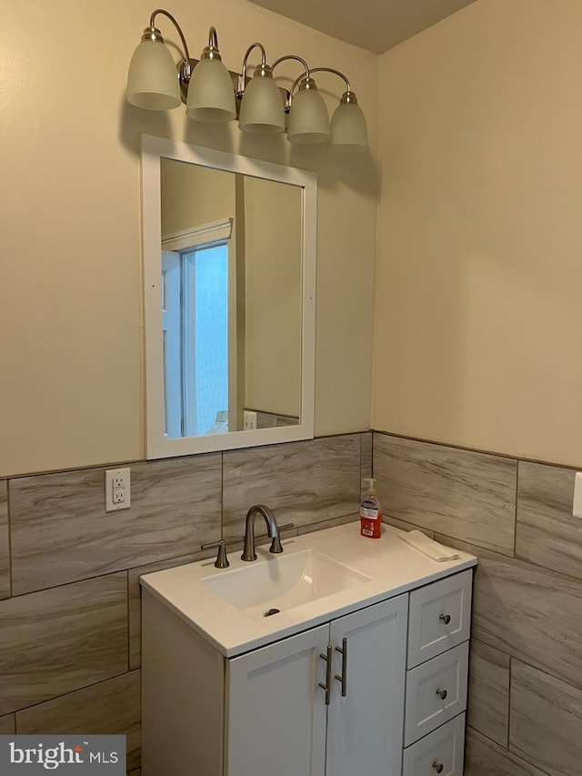 bathroom featuring vanity and tile walls