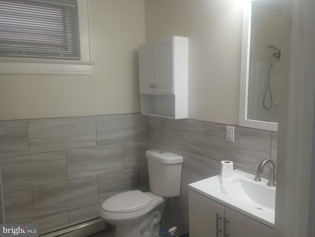 bathroom with tile walls, a baseboard radiator, toilet, and vanity