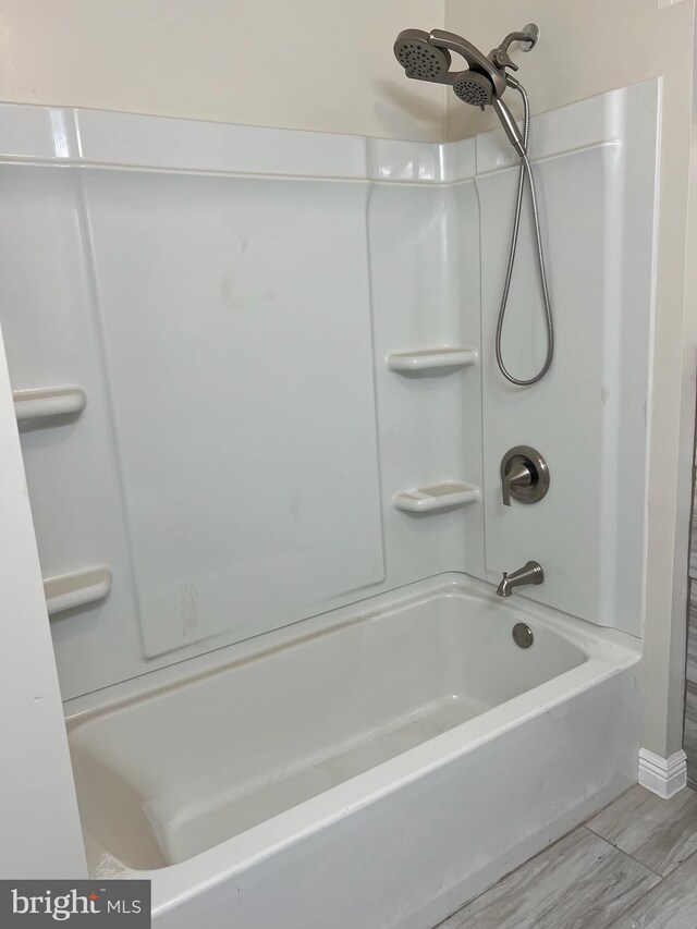 bathroom with hardwood / wood-style floors and shower / bathtub combination