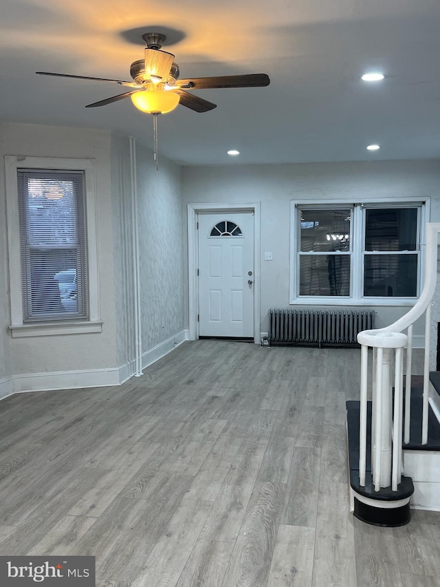 entryway with hardwood / wood-style flooring, radiator heating unit, and ceiling fan