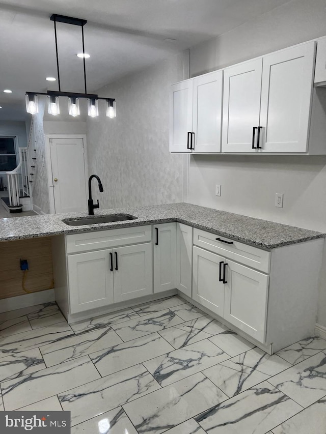 kitchen featuring light stone countertops, sink, white cabinets, and light tile floors