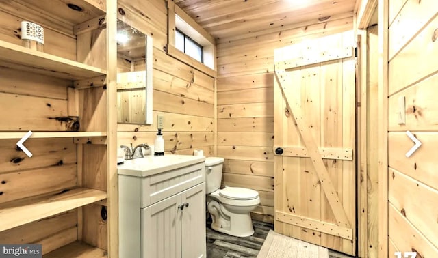 bathroom with hardwood / wood-style floors, wood walls, toilet, wood ceiling, and oversized vanity