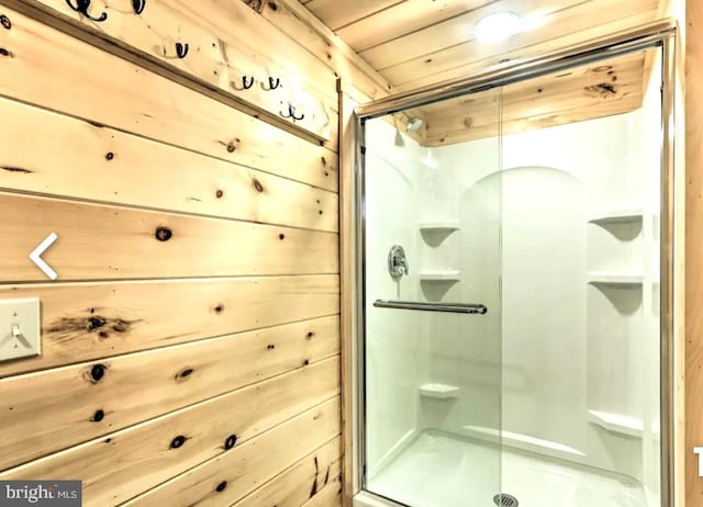 bathroom with an enclosed shower, wooden walls, and wood ceiling