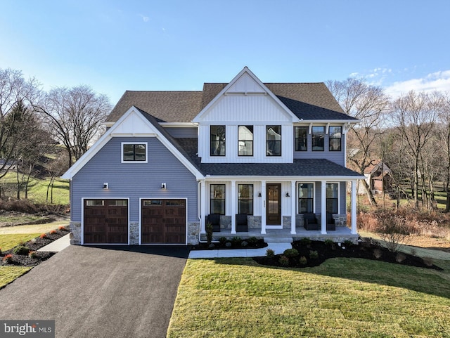 view of front of property with a garage, a front yard, and covered porch