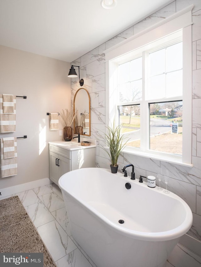 bathroom featuring a bathing tub, tile walls, and vanity