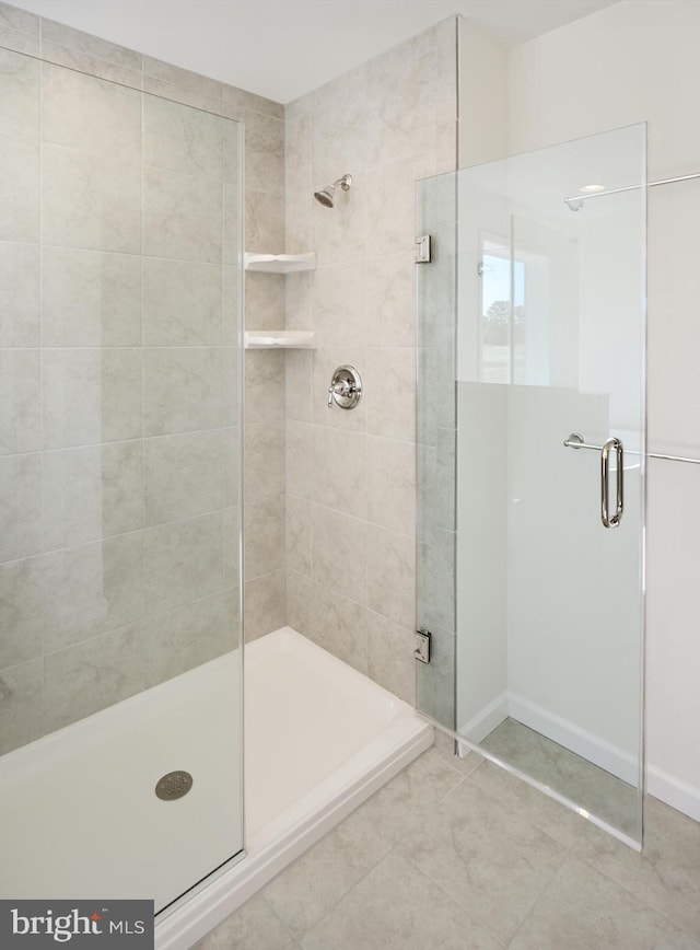 bathroom with tile patterned flooring and a shower with shower door