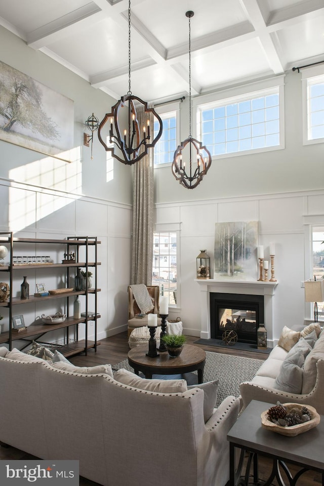 living room featuring coffered ceiling, hardwood / wood-style floors, beamed ceiling, and a multi sided fireplace