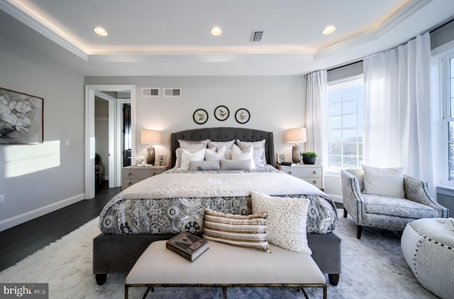 bedroom featuring hardwood / wood-style floors and a tray ceiling