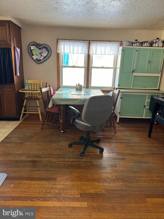 dining room with dark wood-type flooring and a textured ceiling