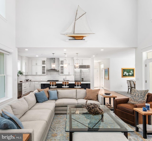 living room with plenty of natural light, beverage cooler, and a high ceiling