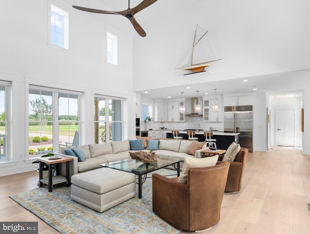 living room featuring ceiling fan, light wood-type flooring, and french doors