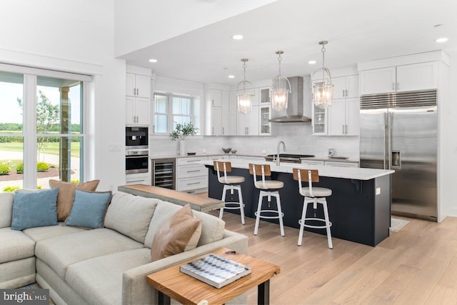 living room featuring beverage cooler and light hardwood / wood-style flooring