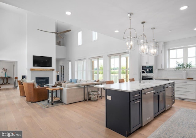 kitchen featuring plenty of natural light, light hardwood / wood-style floors, pendant lighting, and white cabinetry