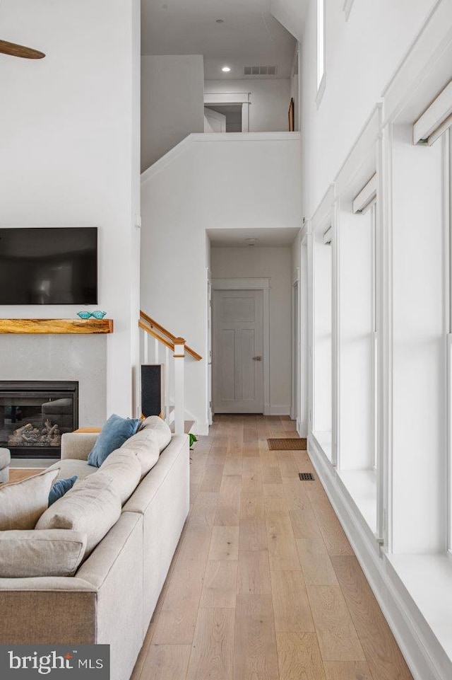 living room with high vaulted ceiling, light hardwood / wood-style floors, and ceiling fan