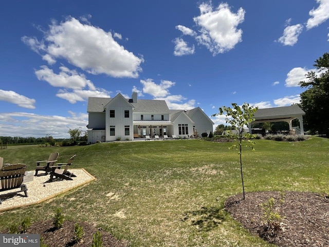 rear view of house with a yard and a gazebo